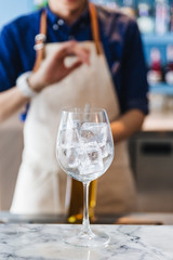 Wine glass with ice inside that ready for making cocktail.