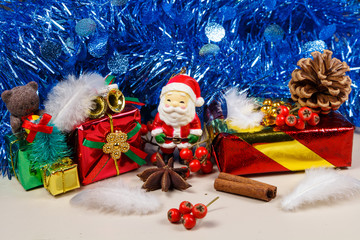 Figurine de Père Noël et paquet cadeau devant une guirlande bleue