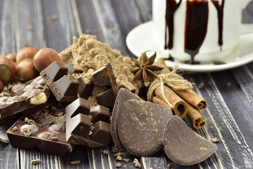 Chocolate pieces with nuts on dark wooden background. Selective focus. Rustic style.