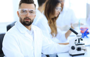 microbiologist and his colleagues are sitting in a modern laboratory