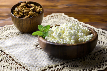 Cottage cheese in a wooden bowl on old wooden background with copy space for your text. Top view
