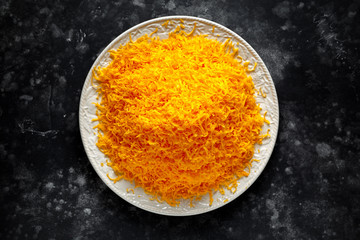 Grated red leicester cheese on plate view from above