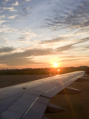 Fototapeta na wymiar Morning sunrise with Wing of an airplane.
