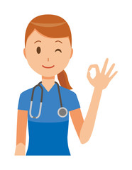Fototapeta premium A female nurse wearing a blue scrub is doing an okay sign