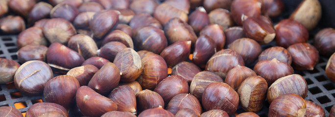 roast chestnuts cooked over the hot grill in the cold autumn day