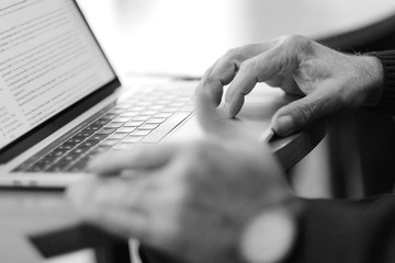 Man's hand brush on the notebook cursor control button while working with information