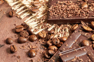 Coffee, chocolate and dried fruits on wood background with linen