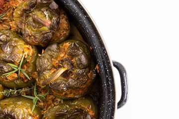 Stuffed green bell peepers in dish, on white background.