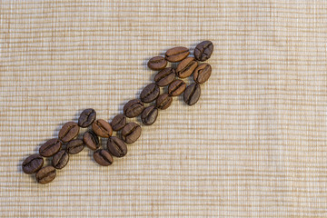 Coffee beans are laid out as a graph rising up on a beige napkin.