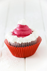 Single homemade chocolate cupcake with frosting white pink cream cheese. Isolated. White wooden background.