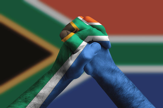 Clasped hands patterned with the South africa flag, multi purpose concept - isolated on flag background