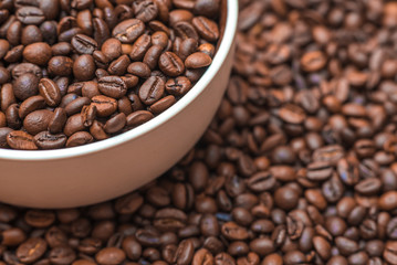 Ceramic cup filled with coffee beans close up. Beverages menu design. Place for text.