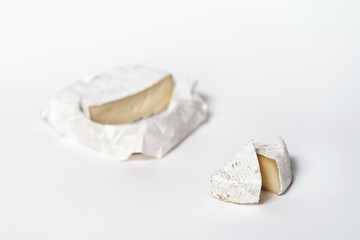 Cheese camembert or brie sliced on white background. Menu design restaurant. Top view design photo. Cheese in white paper.
