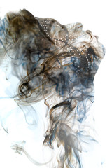 Double exposure of a dark skinned man with dreadlocks and closed eyes combined with a photograph of a smoke texture