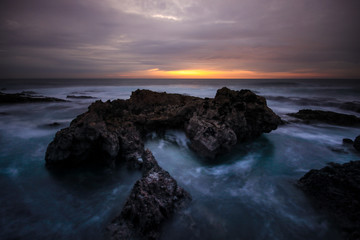 Long exposure in amazing Wild rock beach at the sunset.