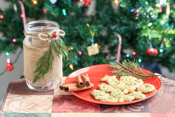Christmas cookies on red plate with Christmas tree background