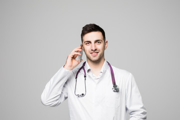 Portrait of handsome young doctor talking by phone isolated on white background
