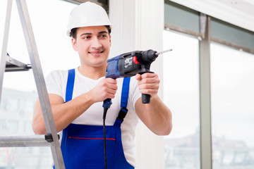 Repairman working with power drill in workshop