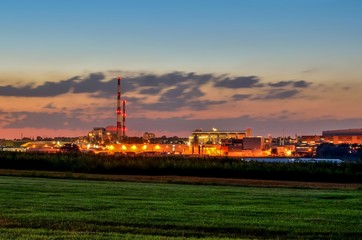 Night industrial landscape. Glowing factories in the city.