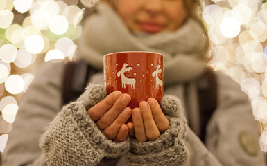 woman holding mug with mulled wine at christmas market