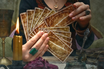 Tarot cards on fortune teller desk table. Future reading. Woman fortune teller holding in hands a...