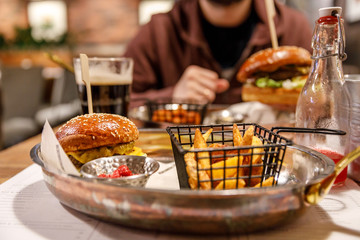 Unhealthy food, high fat and carbs burger in the hand
