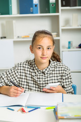 Obraz na płótnie Canvas Teenage girl preparing for exams. Teenage girl doing homework for school.
