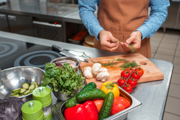 The chef in brown apron cooking in a restaurant kitchen