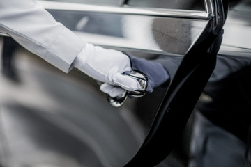 Closeup of Chauffeur opening car door with glove
