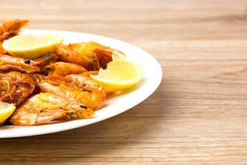 Fried shrimps with lemon. Shrimp fried in a frying pan with butter and garlic.