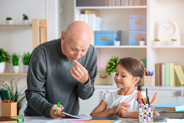 Senior man with his granddaughter at home