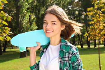 Hipster girl with skateboard in park © Africa Studio