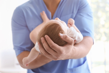 Male doctor holding baby at hospital