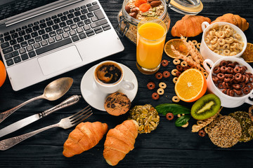 Business breakfast, muesli, coffee, milk, fruits, nuts and seeds, on a wooden surface. Top view. Free space for text.