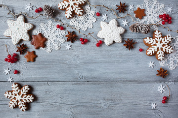 Christmas wooden background with branches, red viburnum berries, gingerbread snowflake, cookies