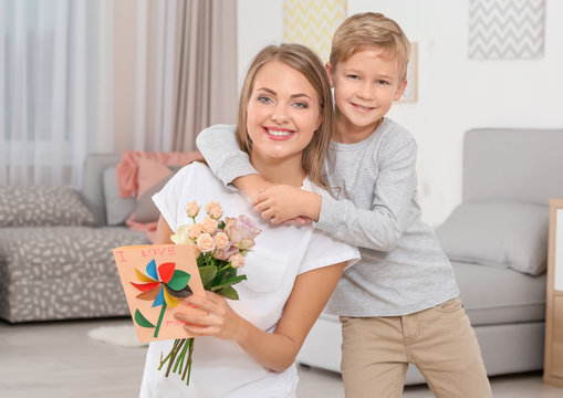 Young woman with her little son and  gifts for Mother's Day at home