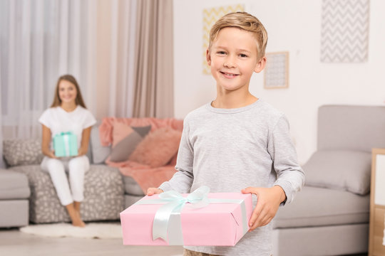 Cute little boy with gift for Mother's Day at home