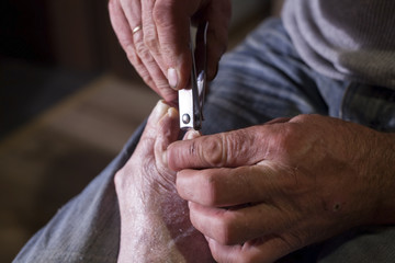 Close up shot of devoted man cutting helping nails of his mother Health Care concept cutter image
