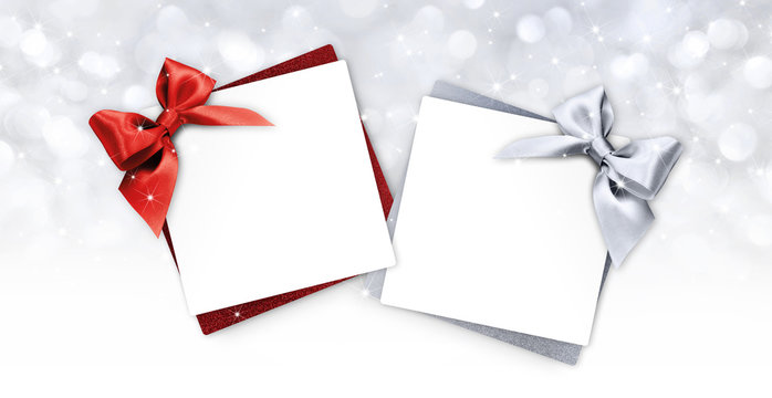gift cards with red and silver ribbon bow Isolated on christmas bright lights background