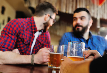 Young people drink beer and talk in a cafe or a pub