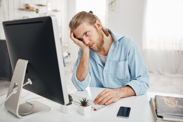 Frustrated tired bearded Caucasian employee touching his head, feeling absolutely exhausted because...