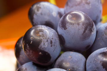 Berry blue wine grapes on a red saucer