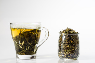 Tea in a glass on a white background. Green or fruit tea.