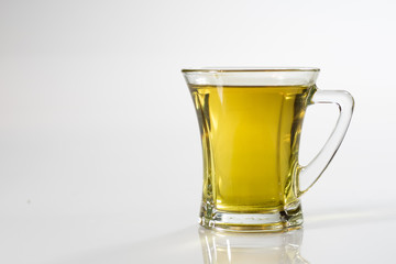 Tea in a glass on a white background. Green or fruit tea.