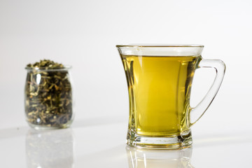 Tea in a glass on a white background. Green or fruit tea.