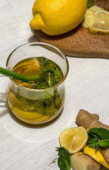 Hot tea with ginger, lemon and mint on a white background. Healthy life, treatment of colds