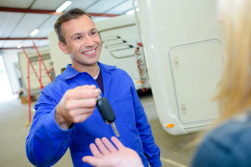 Mechanic handing key to client