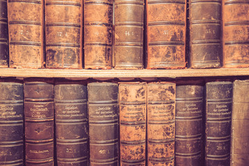 Old books on wooden shelf.