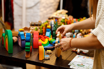 Wooden bright toy in woman hand, handmade christmas market