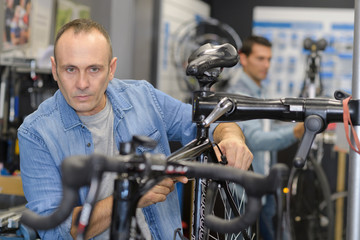 man checks a bike before buying in the sports shop